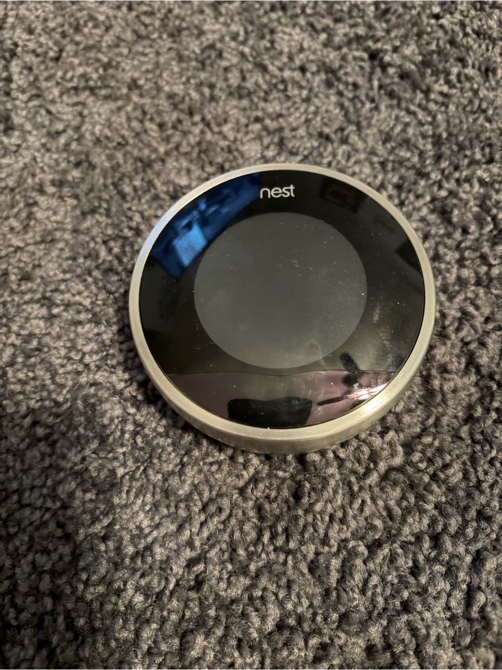 NEST thermostat- black and silver circular device backplate